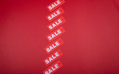 Diagonal row of red sale tags on a red background. Ideal for advertising promotions.