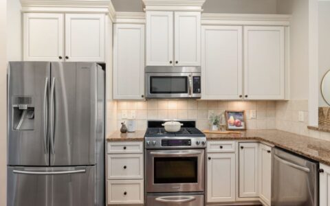 Elegant kitchen featuring stainless steel appliances and classic white cabinetry.